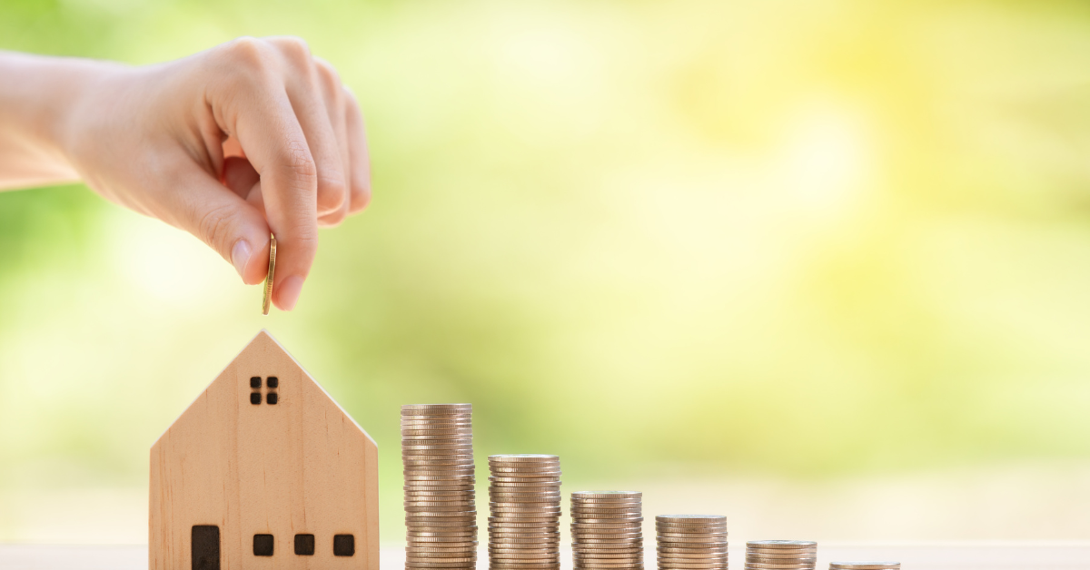 building wealth through investment property - image of man holding coin on a dummy home representing investment in property and increase in profit