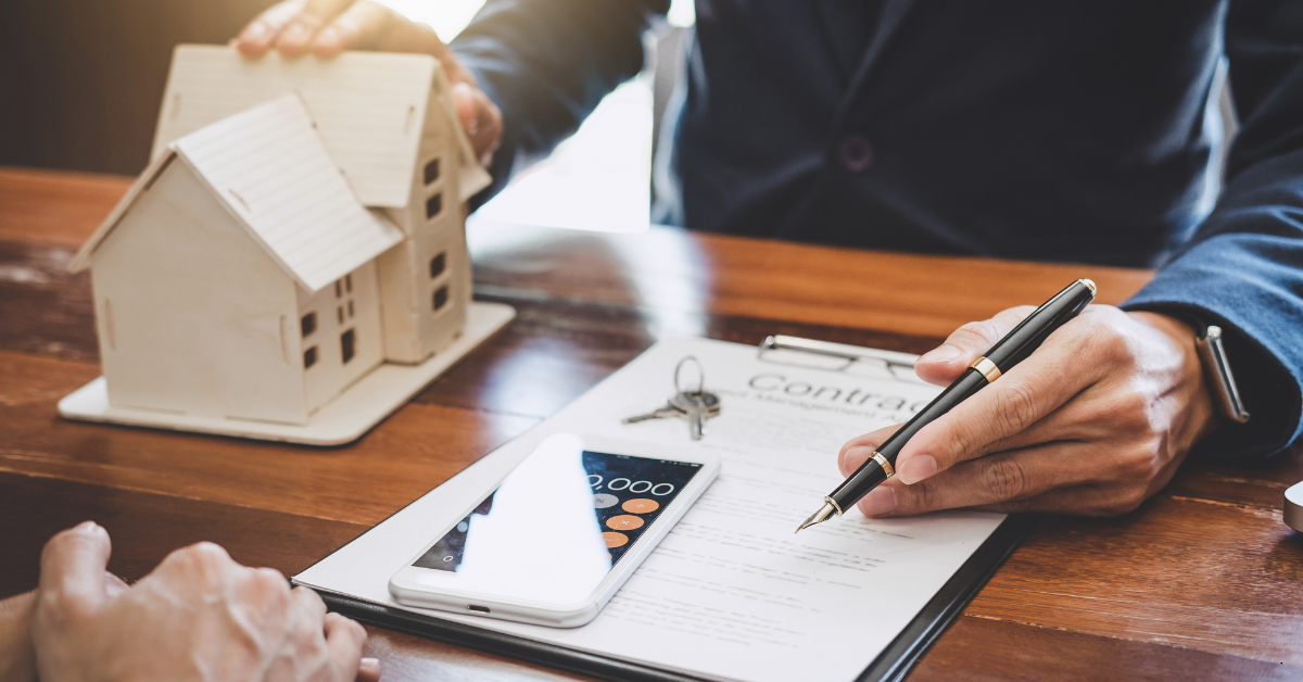 Lenders Mortgage Insurance LMI - Image of a finance professional showing mortgage contract to a person with a dummy house on the table