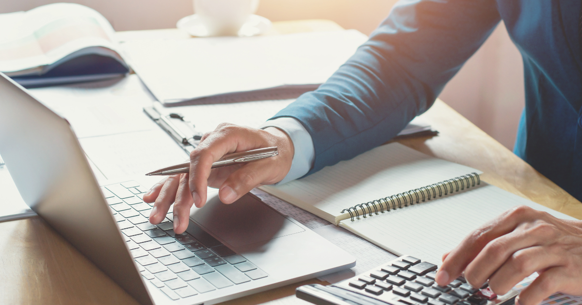 a man calculating interest rate rise in calculator and laptop