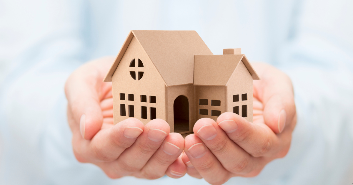 A Man is showing a dummy house demostrating Investment Property or property investment opportunities in Australia