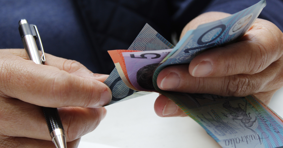 A person is counting his Australian dollars while calculating cash interest rate