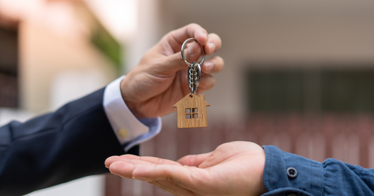 A property broker is handing over a house to a first homebuyer