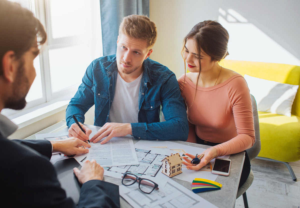6 Top Conversations Every Aussie Couple Should Have Before Investing in Property Together in 2025 1 A couple talking to a property broker for investing in property